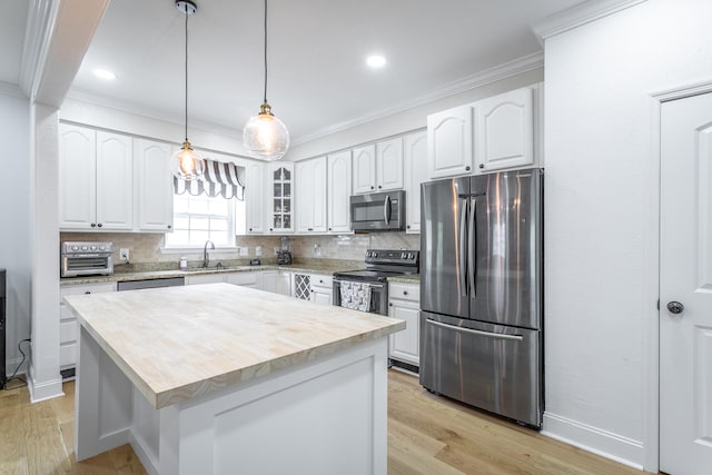 kitchen with a center island, stainless steel appliances, backsplash, and white cabinetry