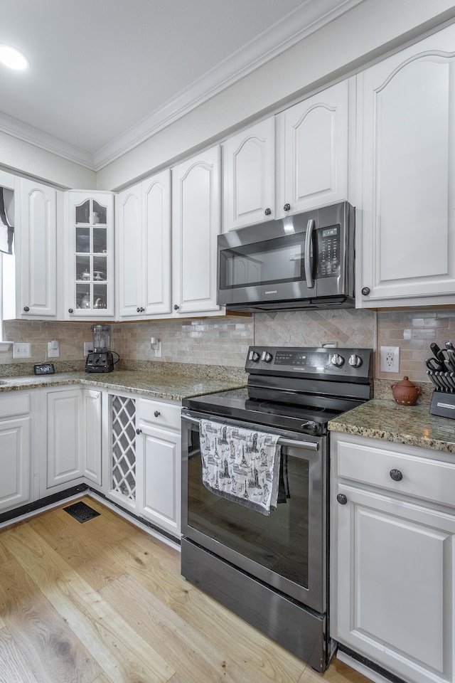 kitchen with range with electric cooktop, crown molding, white cabinets, and light hardwood / wood-style floors