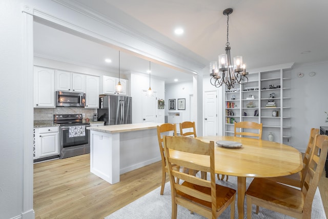 dining space featuring crown molding, light hardwood / wood-style flooring, and a chandelier