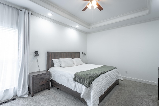 bedroom with ceiling fan, light colored carpet, a raised ceiling, and crown molding