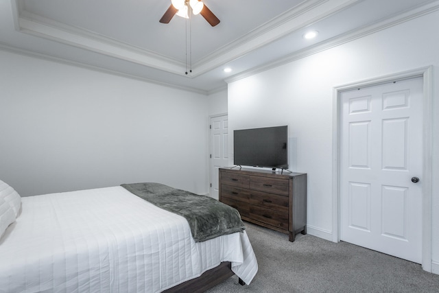 bedroom with crown molding, ceiling fan, carpet, and a tray ceiling