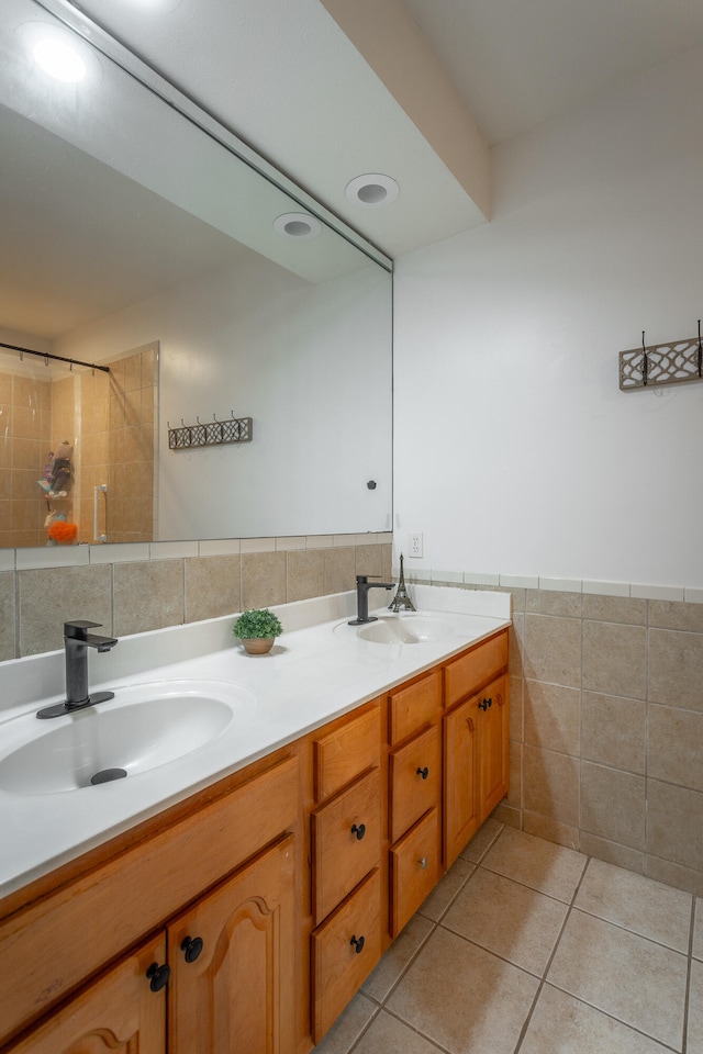 bathroom with vanity, tile walls, tiled shower, and tile patterned flooring