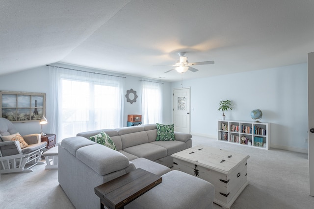 living room featuring lofted ceiling, light colored carpet, ceiling fan, and a textured ceiling