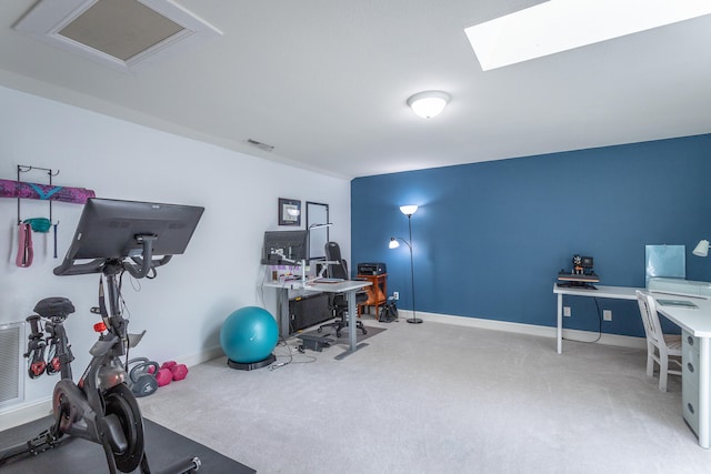 exercise area with a skylight and carpet floors