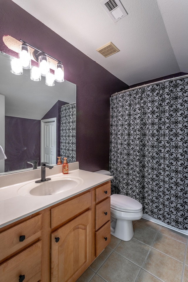 bathroom featuring vanity, toilet, tile patterned floors, and lofted ceiling