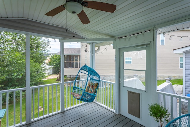 unfurnished sunroom with ceiling fan