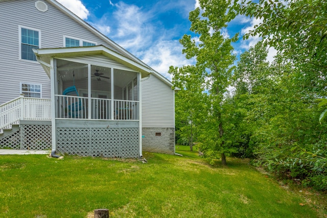 rear view of property featuring a yard, a wooden deck, and ceiling fan