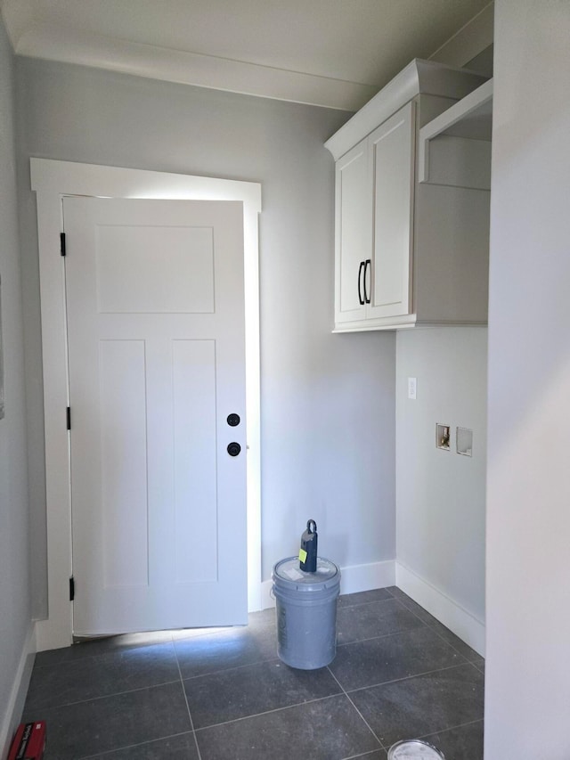 clothes washing area featuring hookup for a washing machine and dark tile patterned flooring