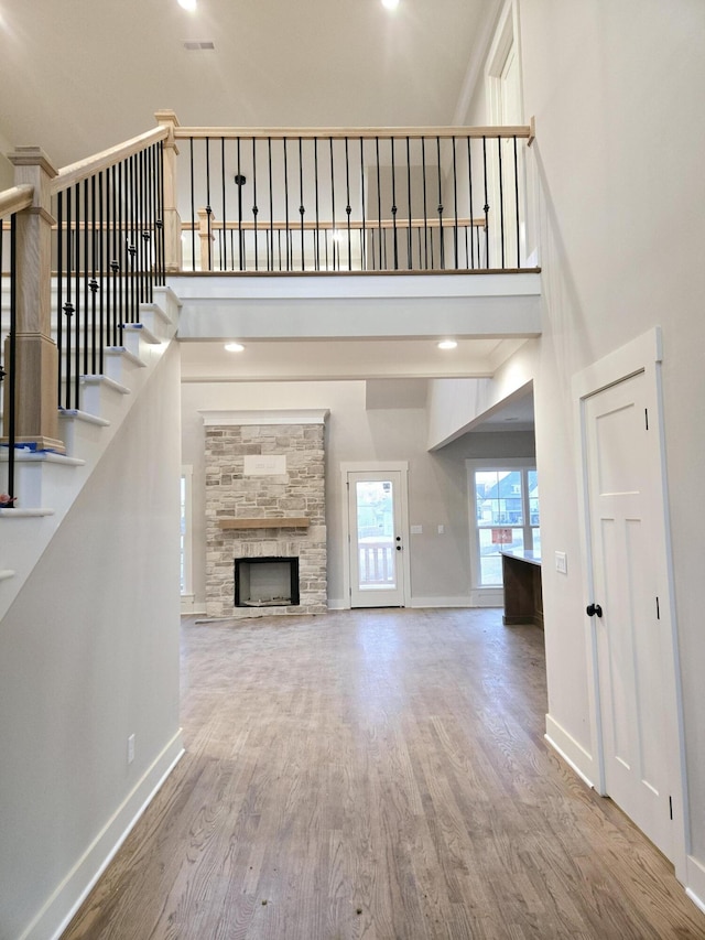 unfurnished living room with hardwood / wood-style flooring, a fireplace, and a high ceiling