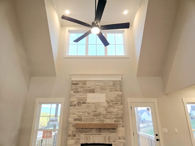 details featuring ceiling fan and a stone fireplace