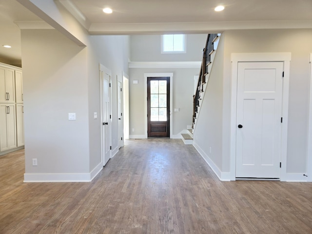 foyer with hardwood / wood-style flooring and crown molding