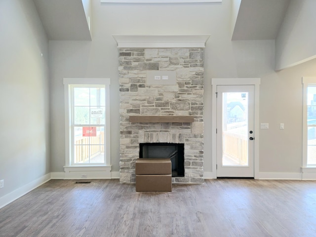 unfurnished living room with a healthy amount of sunlight, a fireplace, and light hardwood / wood-style floors