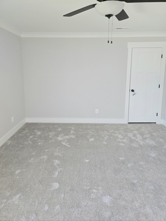 spare room with ornamental molding, a ceiling fan, carpet, and baseboards