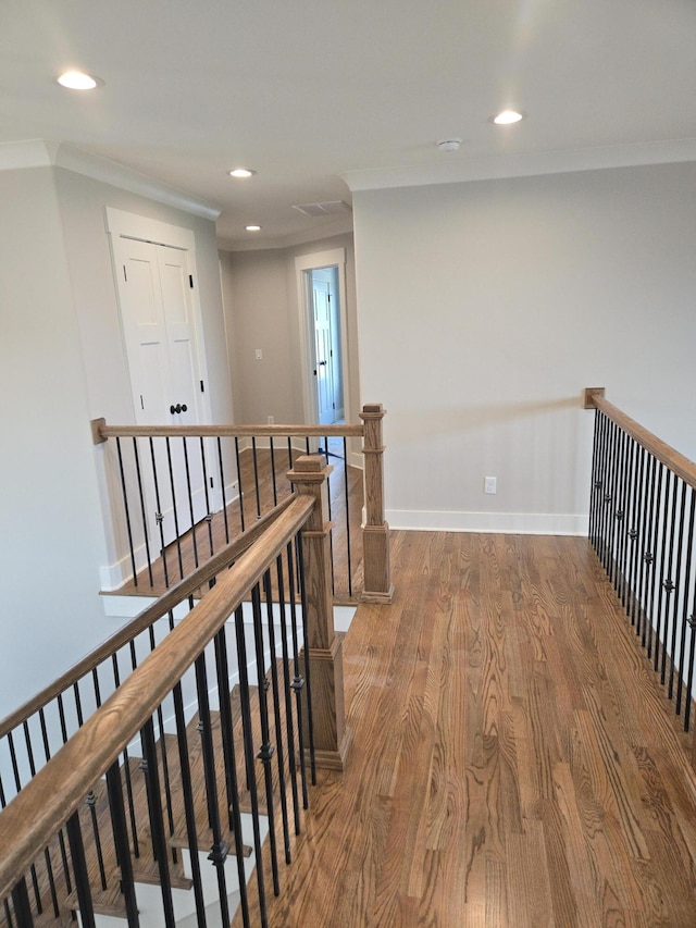 hall featuring recessed lighting, an upstairs landing, baseboards, ornamental molding, and wood finished floors
