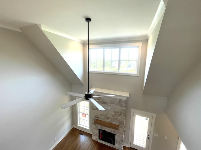 unfurnished living room with wood finished floors, a fireplace, baseboards, a ceiling fan, and crown molding
