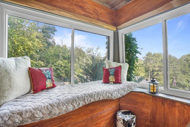 bedroom featuring wooden walls and multiple windows