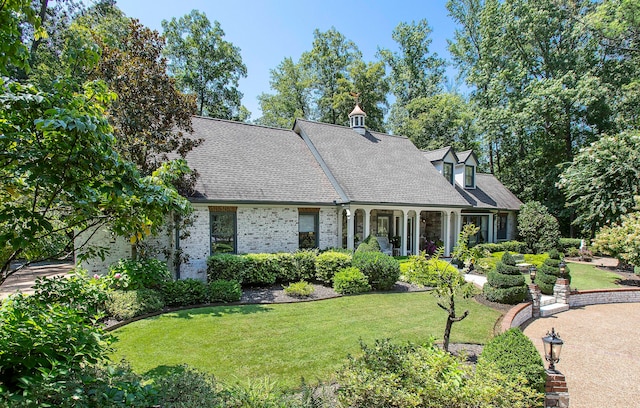 cape cod-style house with a front yard