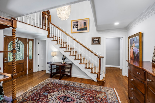 foyer entrance with wood-type flooring, crown molding, and a notable chandelier