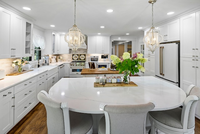 kitchen with dark wood-type flooring, an inviting chandelier, and high quality appliances