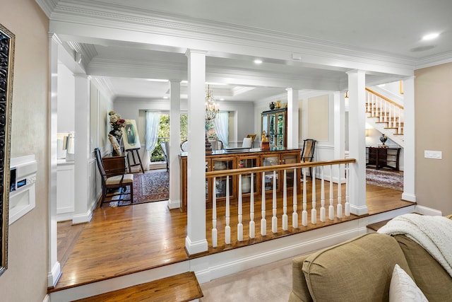 dining area featuring light hardwood / wood-style floors, crown molding, and ornate columns