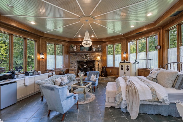 tiled living room with a wealth of natural light, a chandelier, and wooden ceiling