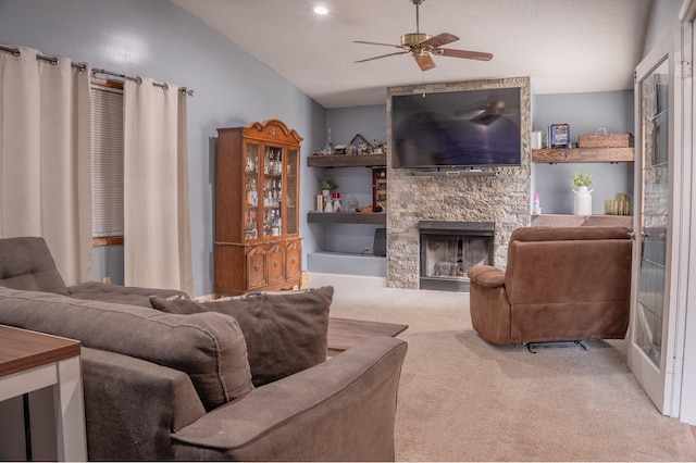 living area featuring a fireplace, vaulted ceiling, light carpet, and ceiling fan