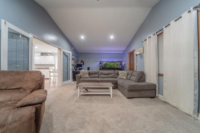 living area with lofted ceiling, recessed lighting, and light colored carpet