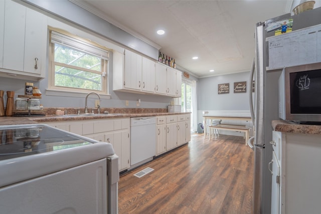 kitchen with white appliances, a sink, and white cabinetry