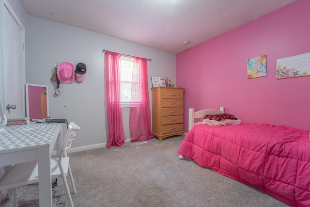 carpeted bedroom with a textured ceiling and baseboards