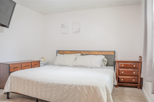 bedroom with light carpet and baseboards