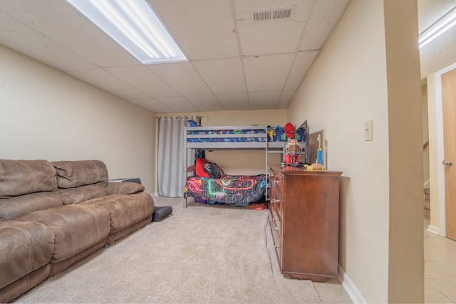 interior space with a paneled ceiling, light carpet, and visible vents