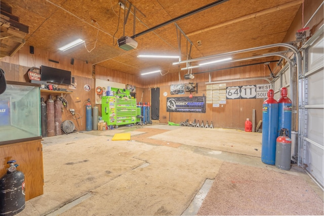 garage with wood walls and a garage door opener