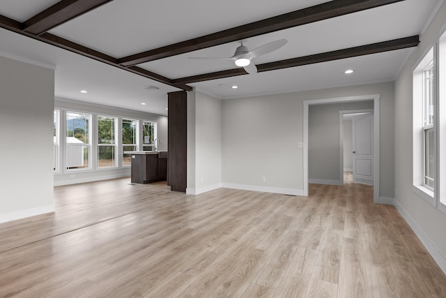 unfurnished living room with ornamental molding, beam ceiling, light wood-type flooring, and ceiling fan