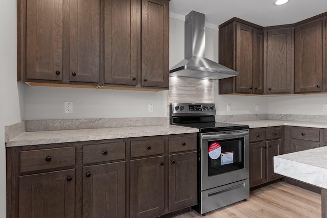 kitchen featuring wall chimney exhaust hood, light hardwood / wood-style flooring, dark brown cabinetry, and electric stove