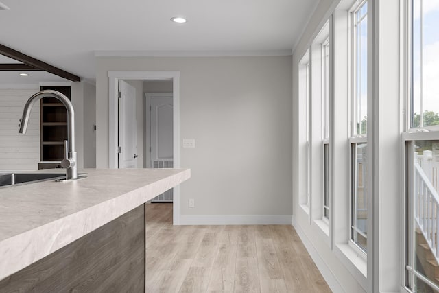 kitchen featuring crown molding, sink, and light hardwood / wood-style floors