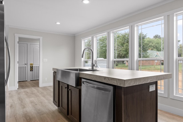 kitchen featuring appliances with stainless steel finishes, a center island with sink, plenty of natural light, and light hardwood / wood-style flooring