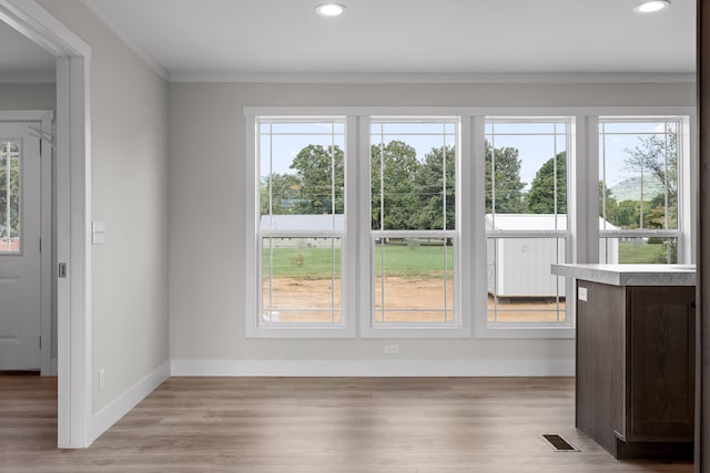 doorway to outside with light hardwood / wood-style flooring and ornamental molding