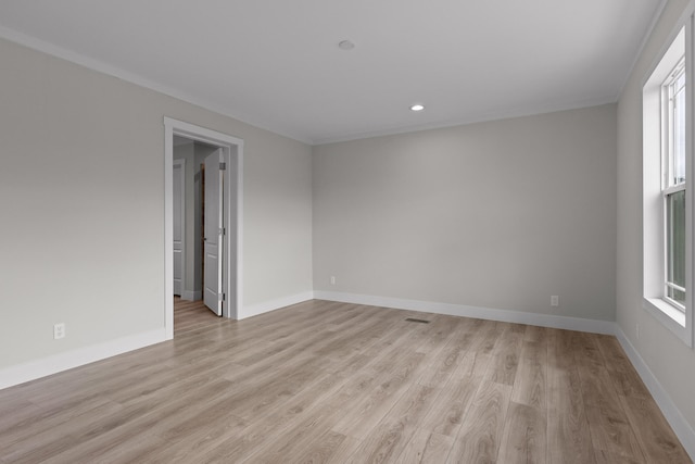 spare room featuring ornamental molding and light hardwood / wood-style flooring