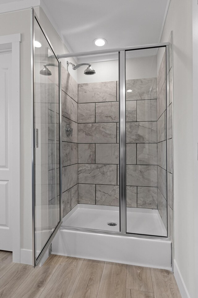 bathroom featuring hardwood / wood-style flooring and walk in shower