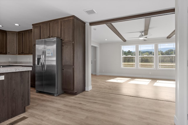 kitchen featuring light wood-type flooring, beamed ceiling, ceiling fan, stainless steel fridge, and dark brown cabinets