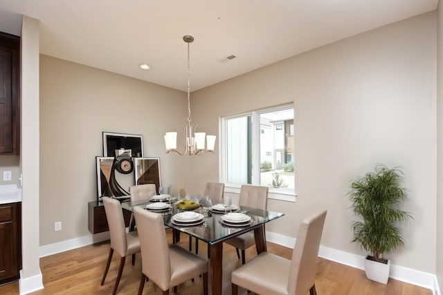 dining area featuring light hardwood / wood-style flooring and a notable chandelier