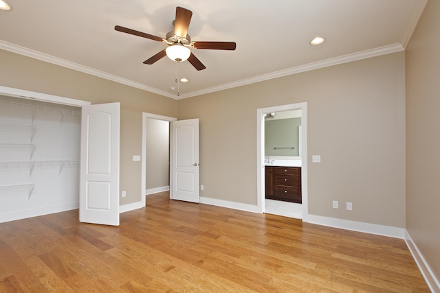 unfurnished bedroom with a closet, ensuite bathroom, light hardwood / wood-style floors, crown molding, and ceiling fan