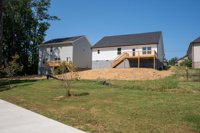 rear view of property featuring a wooden deck and a lawn