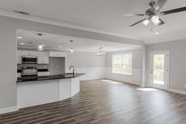 kitchen featuring stainless steel appliances, white cabinets, decorative light fixtures, and dark wood-type flooring