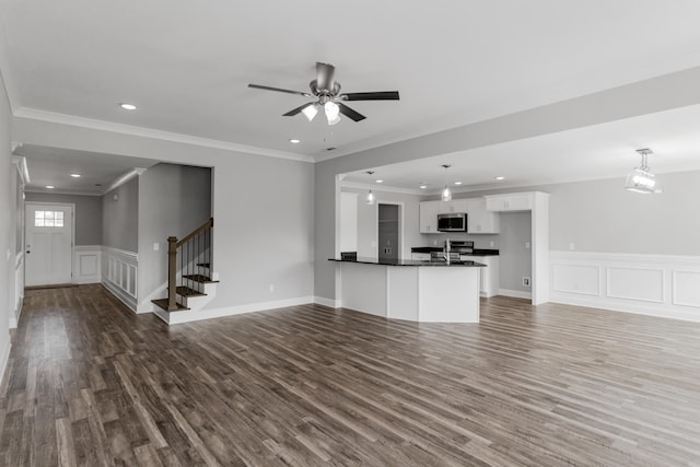 unfurnished living room featuring ornamental molding, hardwood / wood-style flooring, ceiling fan, and sink