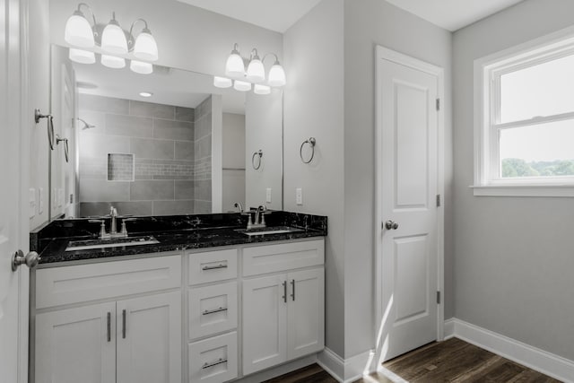 bathroom featuring wood-type flooring, vanity, and tiled shower