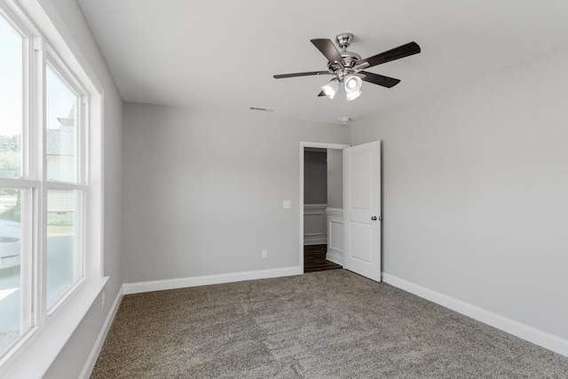 spare room with ceiling fan, carpet flooring, and a healthy amount of sunlight