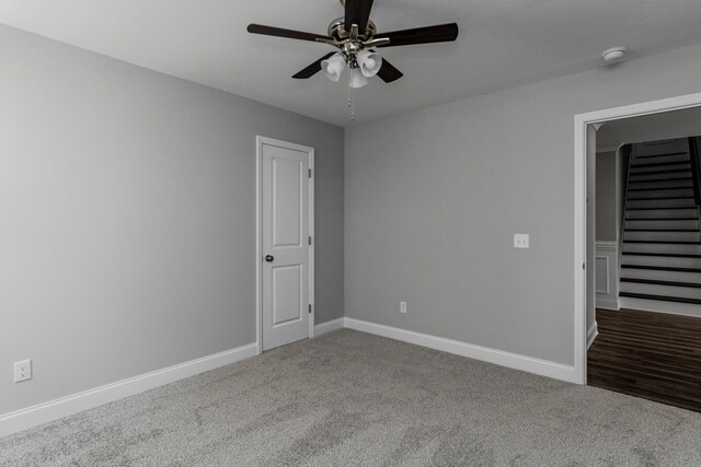 carpeted spare room featuring ceiling fan