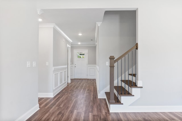 foyer entrance featuring crown molding and dark wood-type flooring