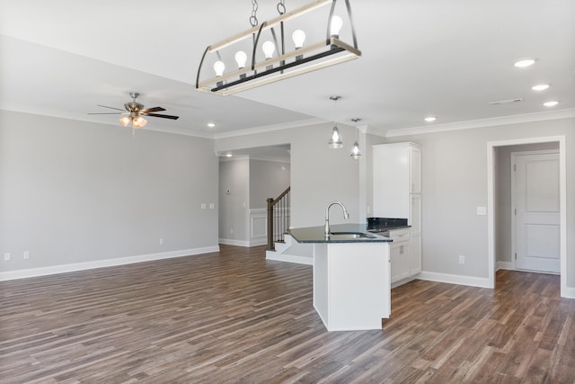 kitchen with pendant lighting, white cabinets, sink, crown molding, and dark hardwood / wood-style flooring